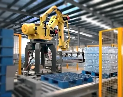 Automatic palletizer stacking cartons onto a pallet at a line end