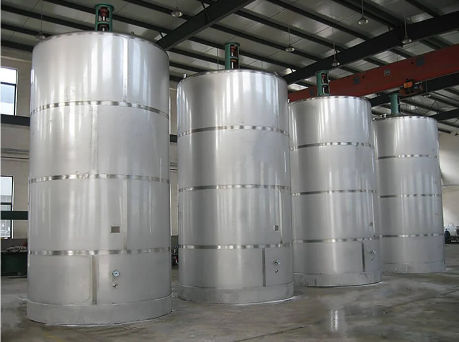 Row of stainless steel milk storage silos inside a processing plant