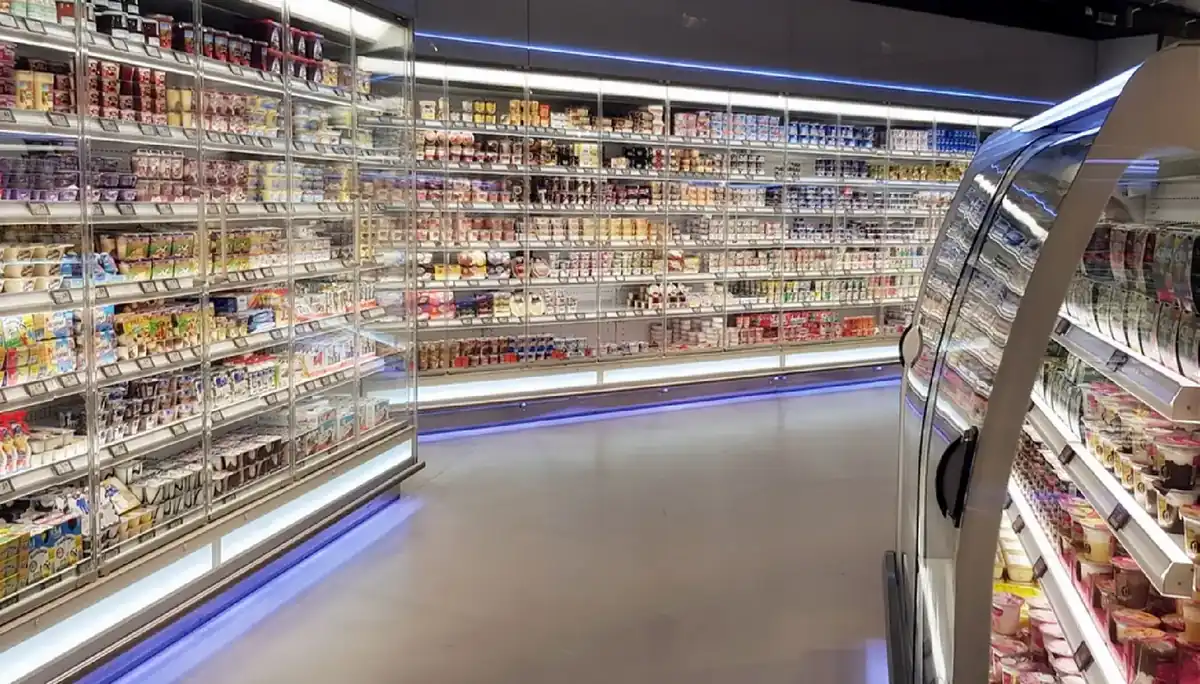 Refrigerated display cases in a supermarket aisle lit with LED cooler modules