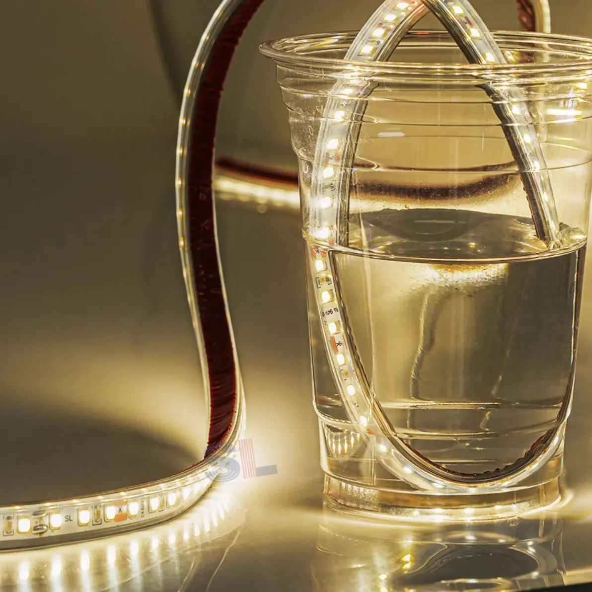 Waterproof LED strip partly submerged in a glass of water while lit