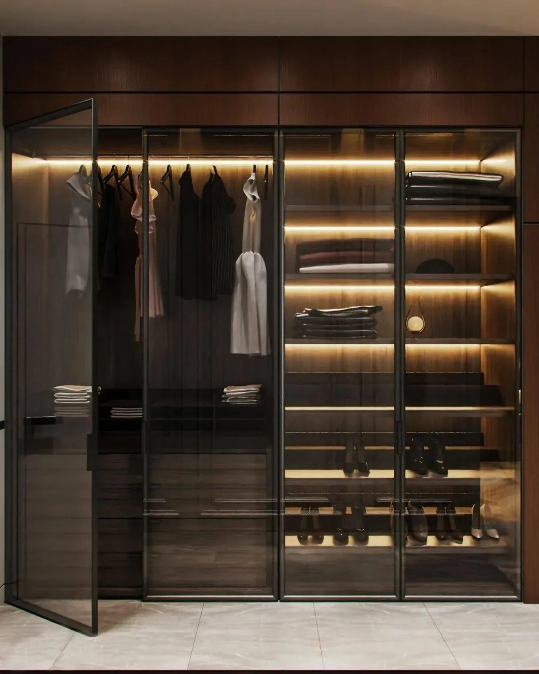Walk in wardrobe with hanging rails lit by concealed LED strip lighting