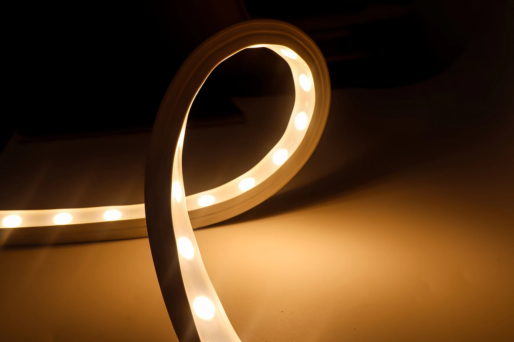 Warm white LED neon flex bent into a loop against a dark background