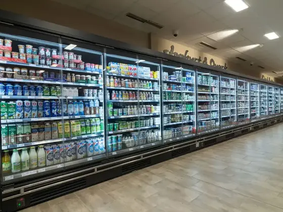 Chilled food display counters in a supermarket lit by LED case lighting