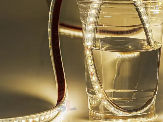 Waterproof LED strip partly submerged in a glass of water while lit