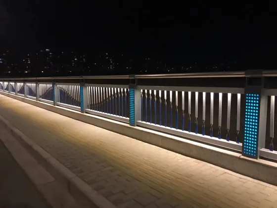 Bridge walkway at night with LED lighting integrated into the railing