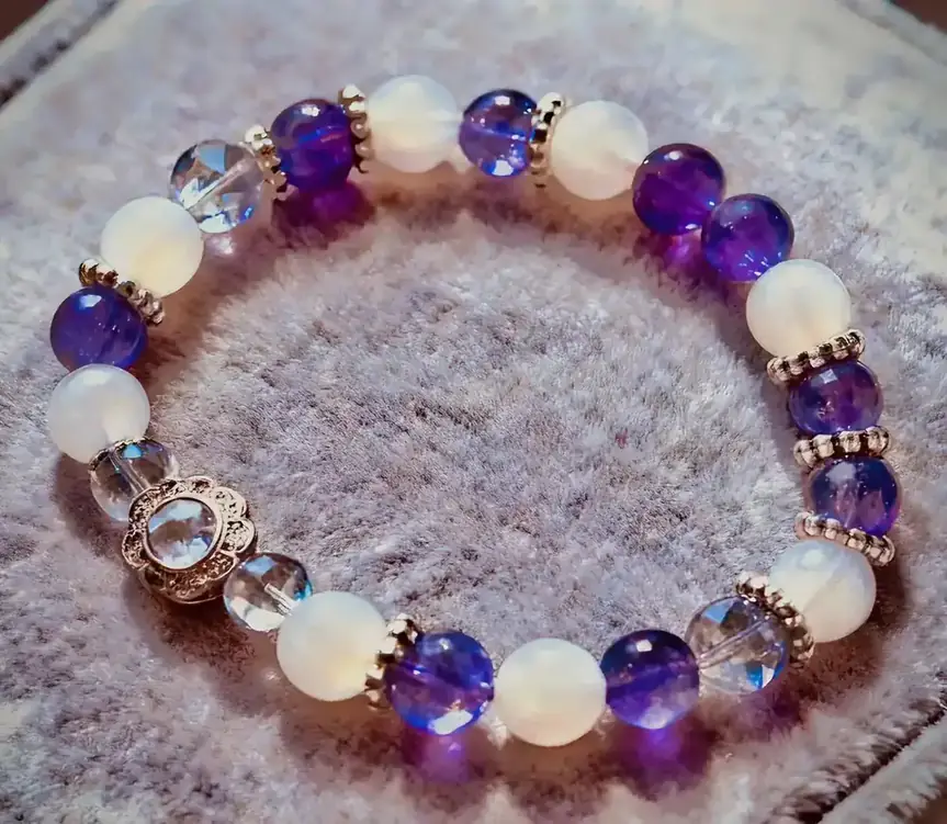 Aurora Blessing purple super seven and purple chalcedony crystal bracelet, the bracelet styled on a surface