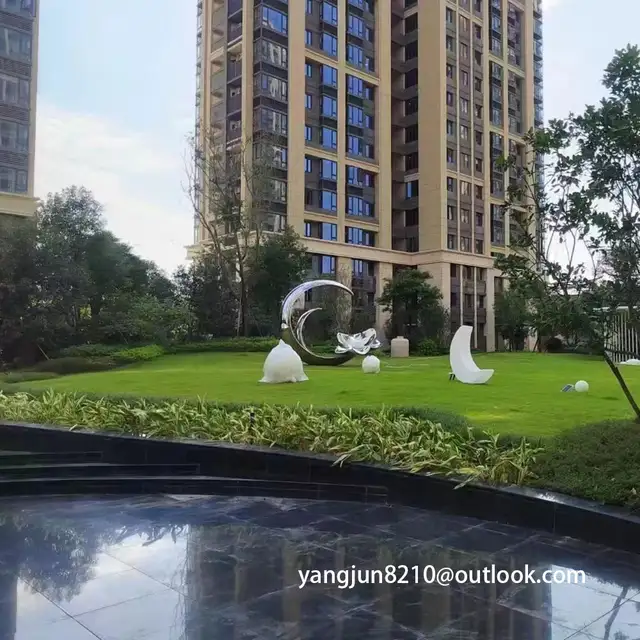 Large outdoor park square apartment playground theatre glowing stainless steel crescent sculpture
