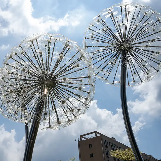 Outdoor park square green space glowing stainless steel dandelion sculpture in close view