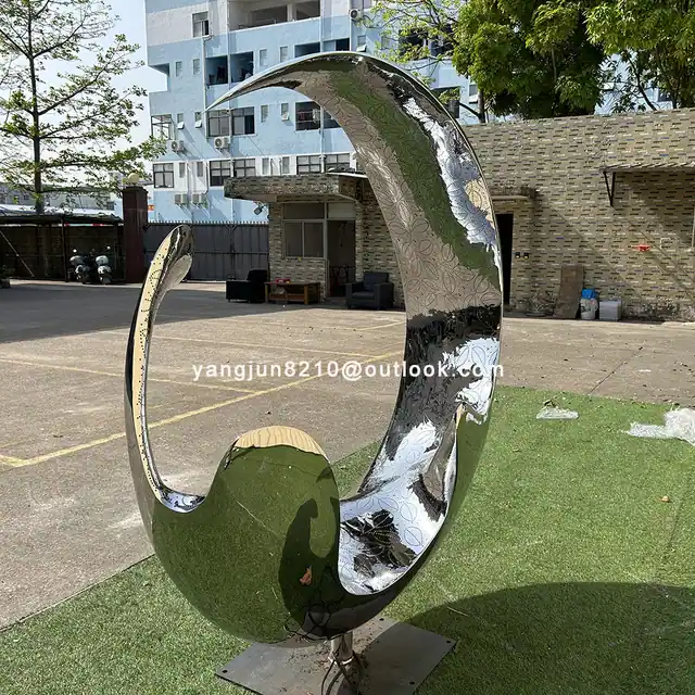 Outdoor square garden courtyard luminous stainless steel crescent sculpture shown in its setting