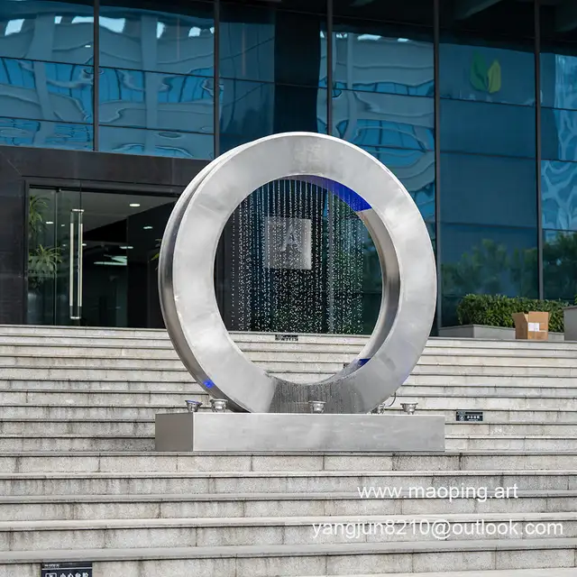 Outdoor square park museum airport beach swimming pool stainless steel ring water curtain sculpture seen from another an