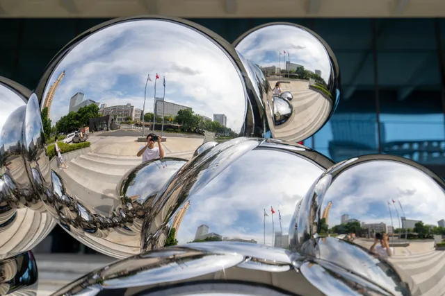 Outdoor stainless steel metal gold sphere sculpture in close view