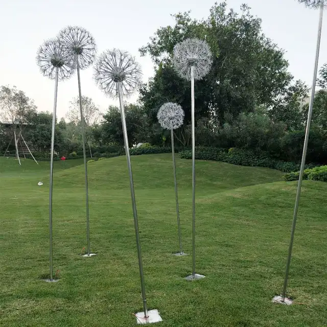 Outdoor park square green space glowing stainless steel dandelion sculpture shown in its setting