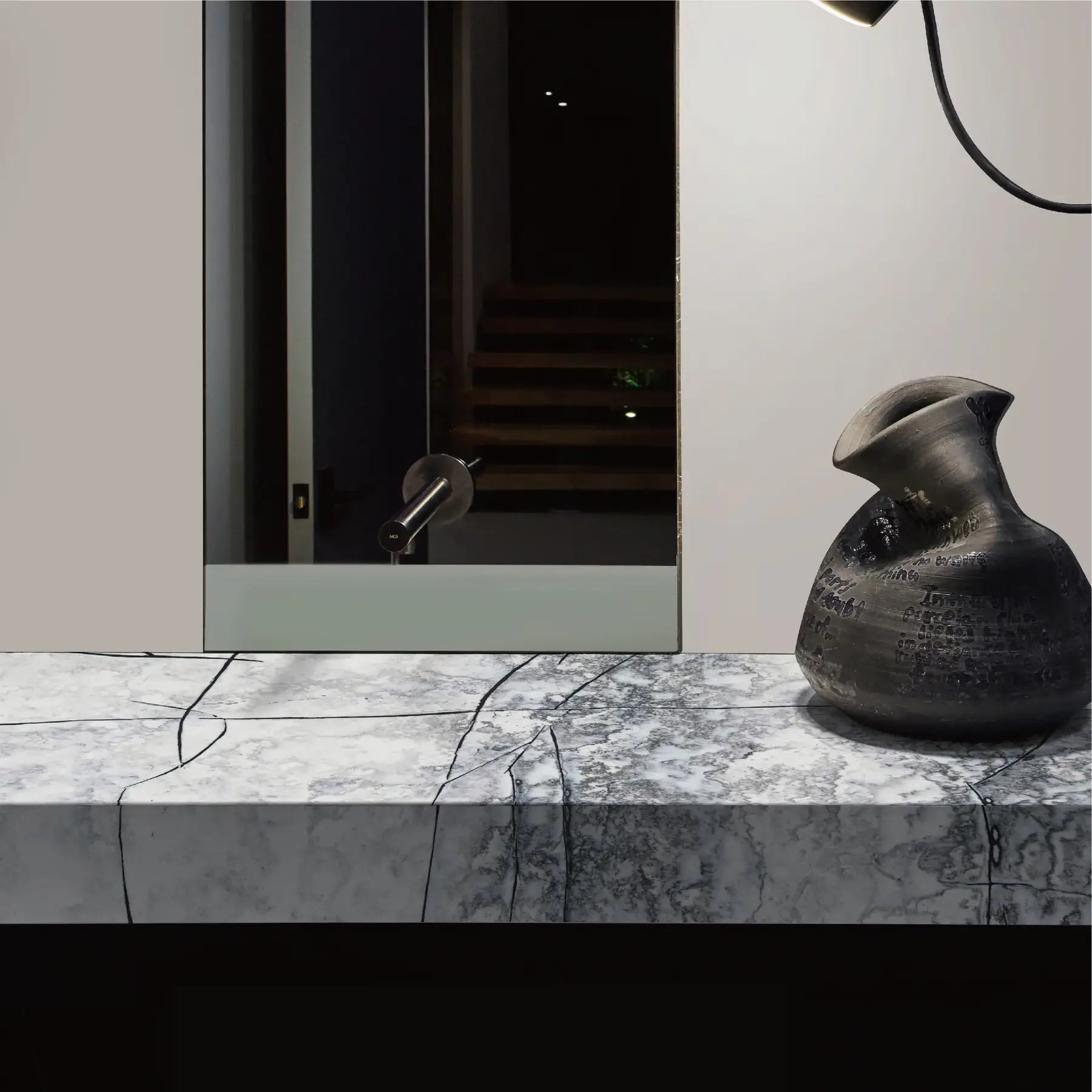 Veined stone vanity top with a wall-mounted tap and mirror in a bathroom