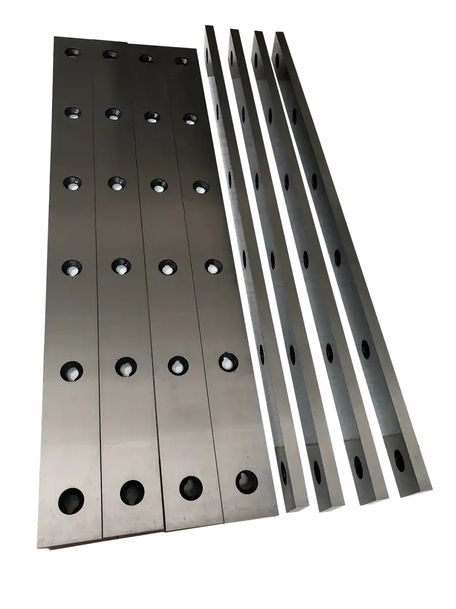 Long industrial metal shear blades with mounting holes against a dark background