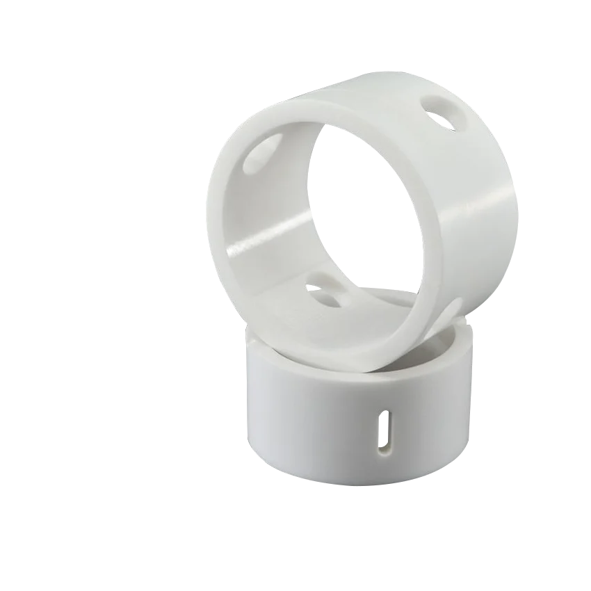 Two white cylindrical plastic or ceramic rings with holes on a white background