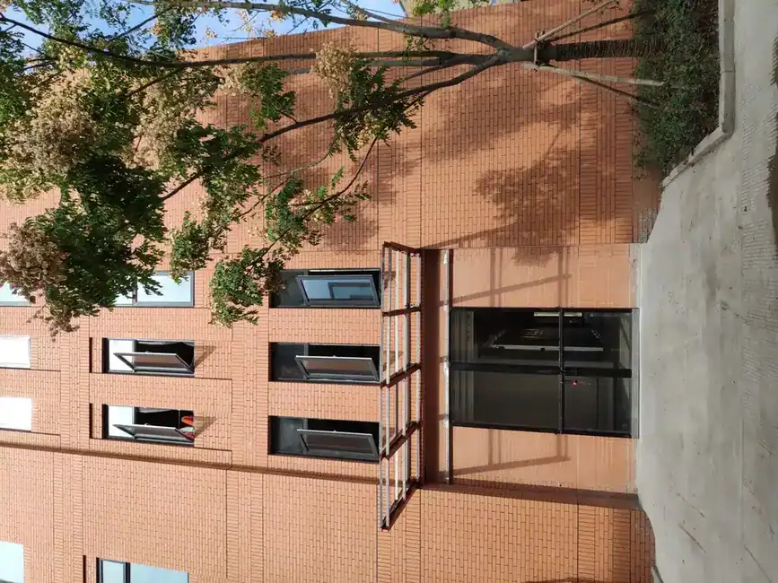 Exterior of a multi-story red brick industrial building with entrance canopy and windows
