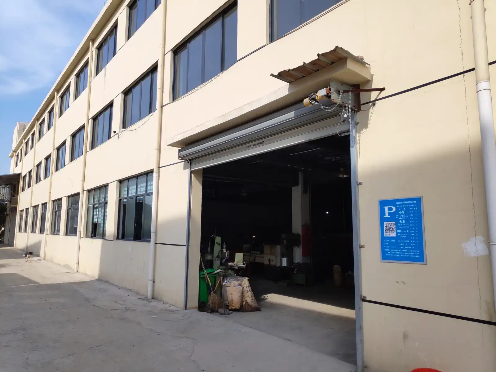Exterior view of an industrial factory building entrance with open bay door