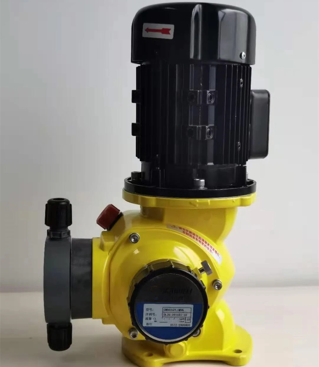 Industrial chemical metering pump with black electric motor and yellow pump head on white background