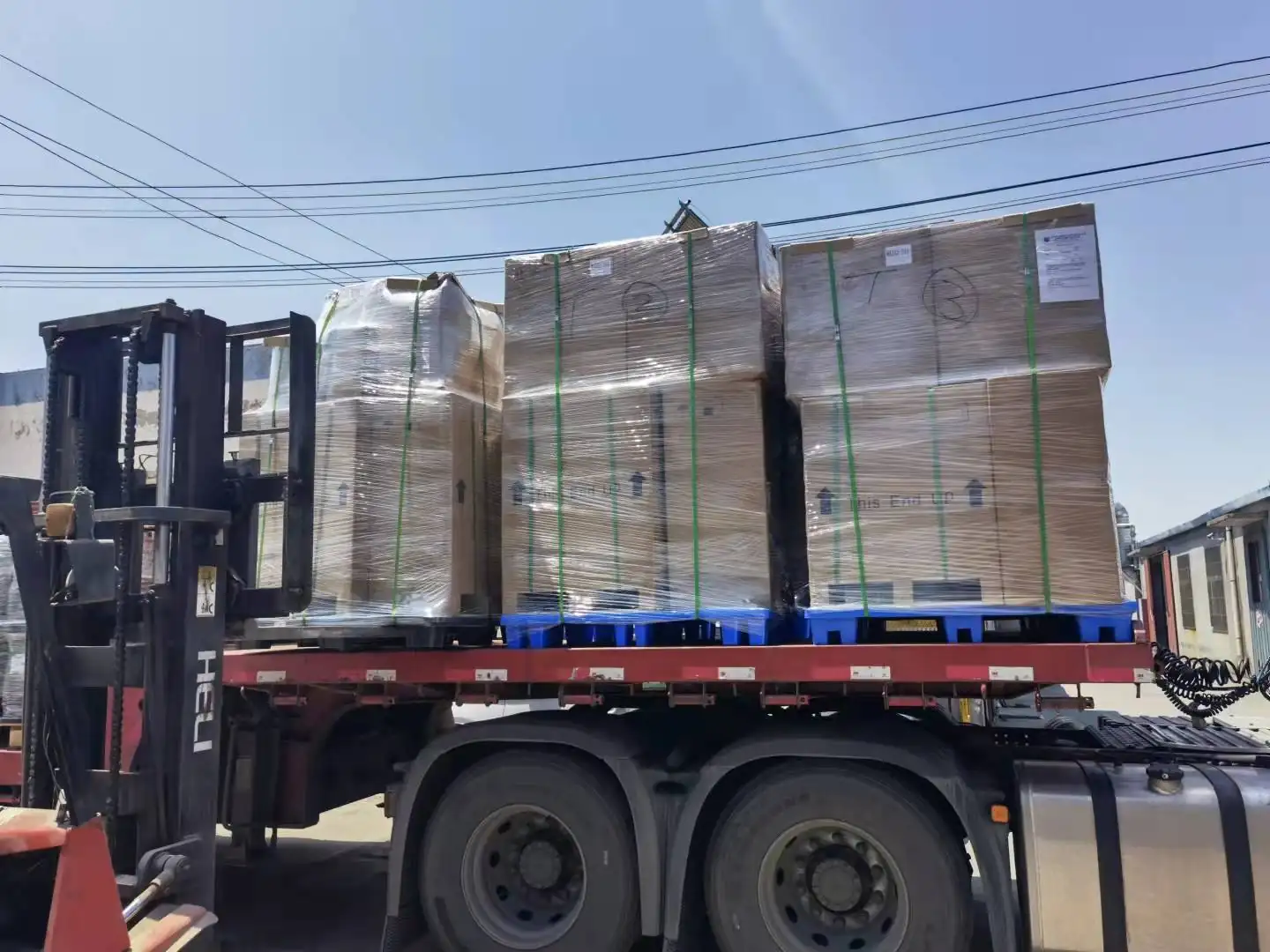 Shrink wrapped pallets of Nuodean pumps loaded onto a flatbed truck