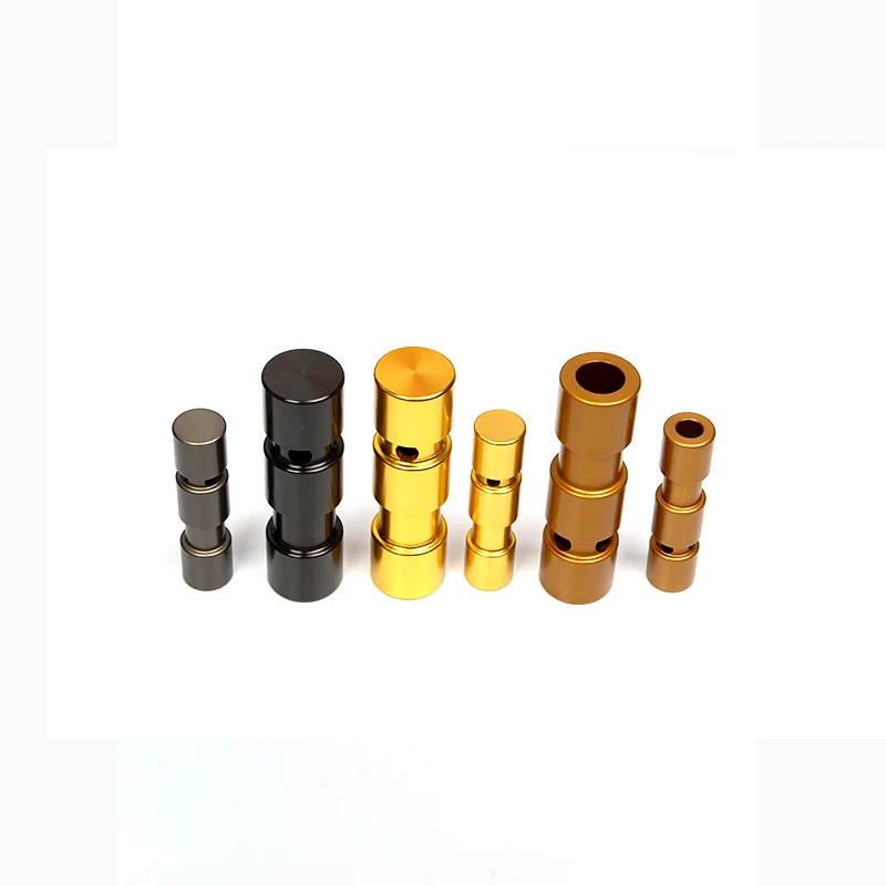 Six anodized cylindrical metal parts in black, gold, and bronze arranged on a white background.
