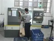 CNC lathe cell under operator control, running secondary machining on die cast blanks.