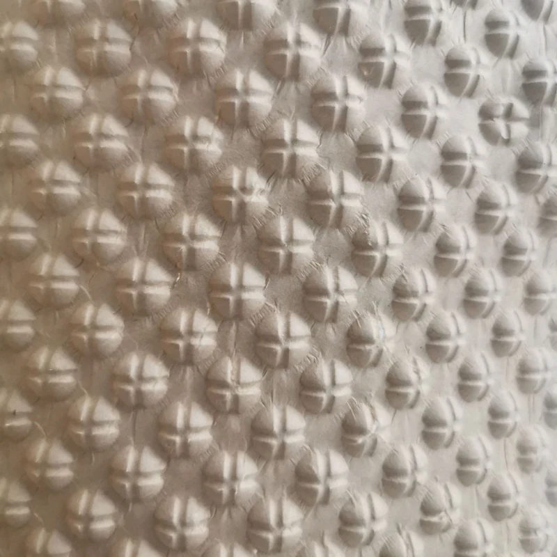 Embossed kraft paper bubble web leaving the heated rollers