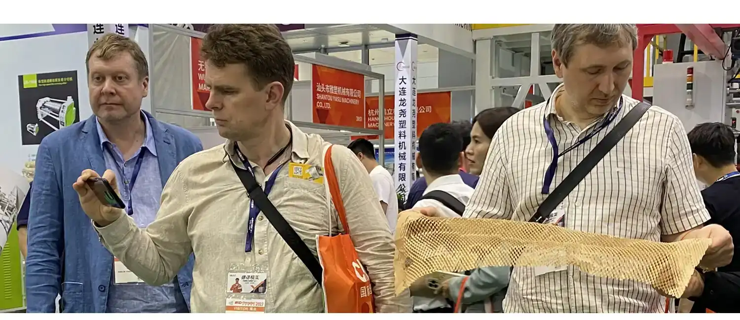 Buyers examining honeycomb cushioning paper at an Emerson Machinery exhibition stand