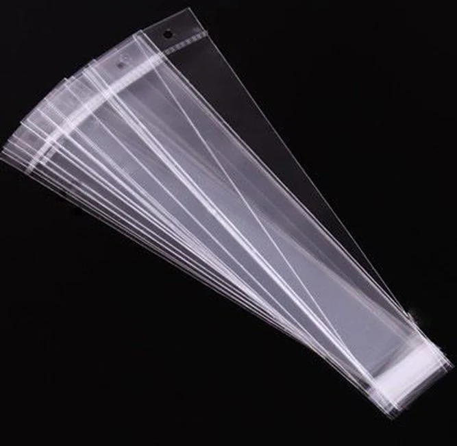 Fanned stack of clear plastic packaging sleeves on black background