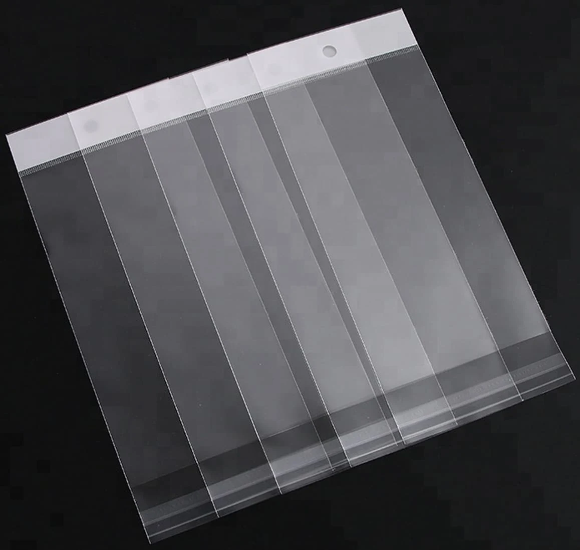 Transparent plastic hanging bags overlapped in a row on black background