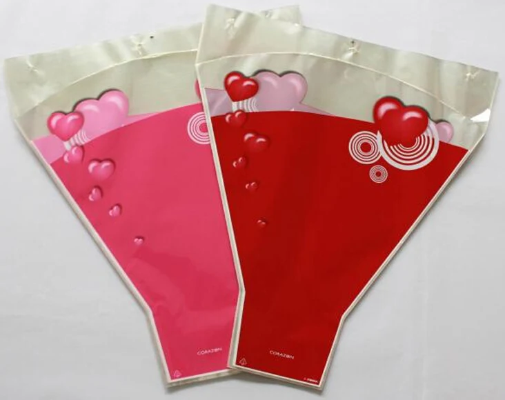 Two plastic flower bouquet sleeves with heart designs in pink and red
