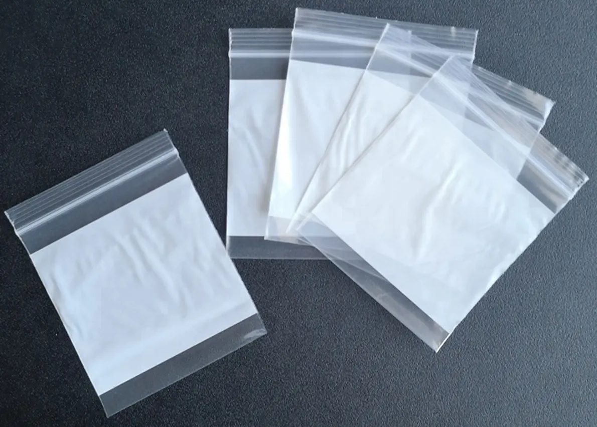 Five clear resealable plastic zip bags on dark gray surface