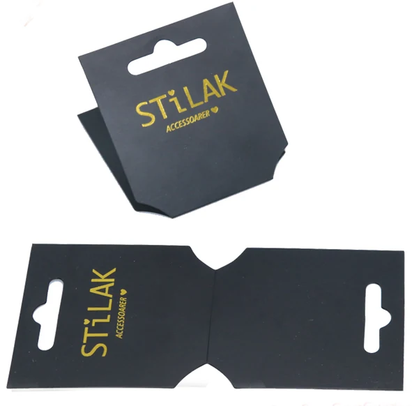 Two black cardboard hang tags with gold lettering shown folded and flat on white background