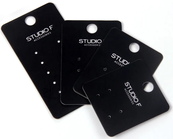 Four black rectangular jewelry display cards with hang holes on white background