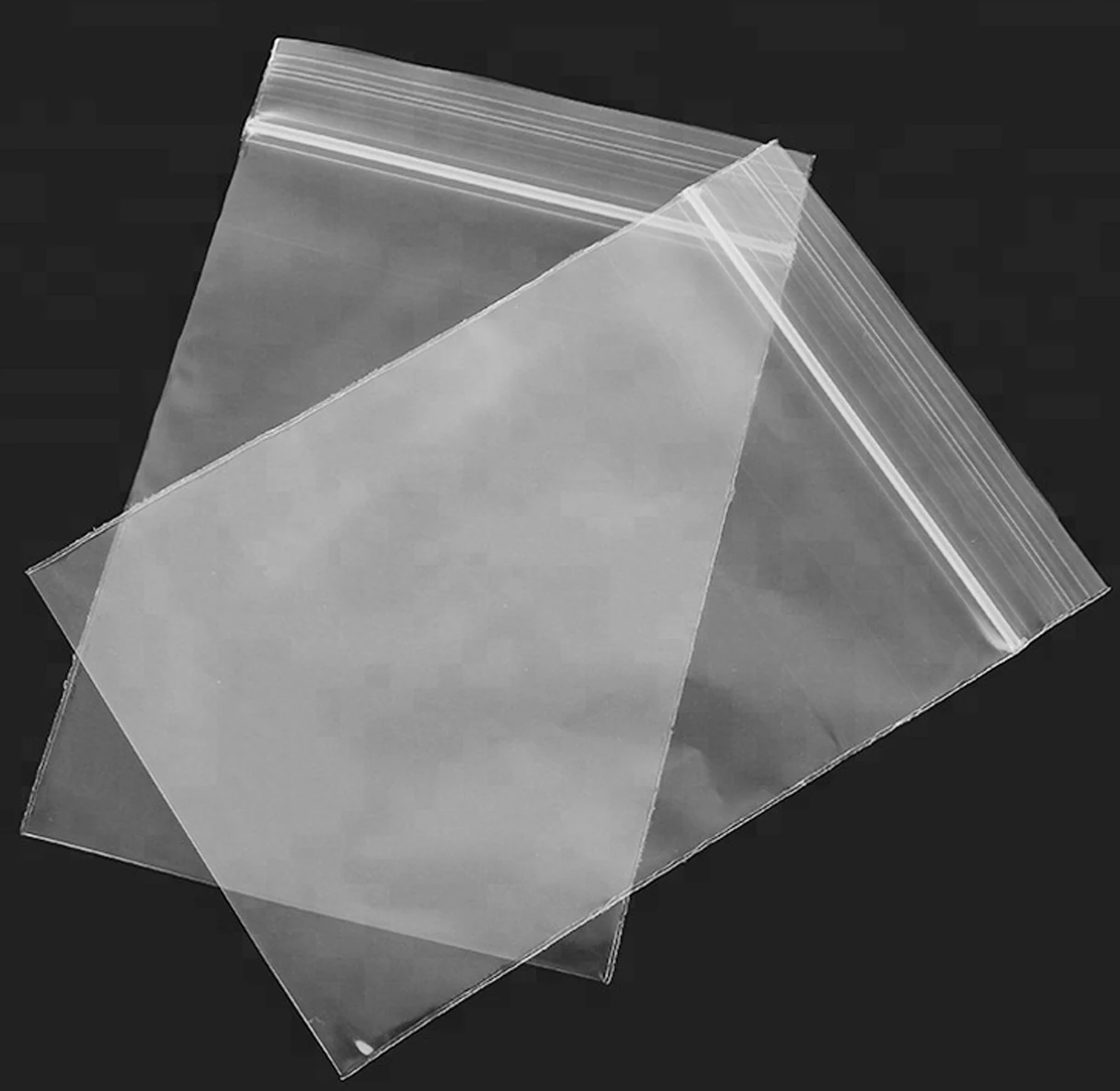 Two clear resealable plastic zip bags overlapping on black background