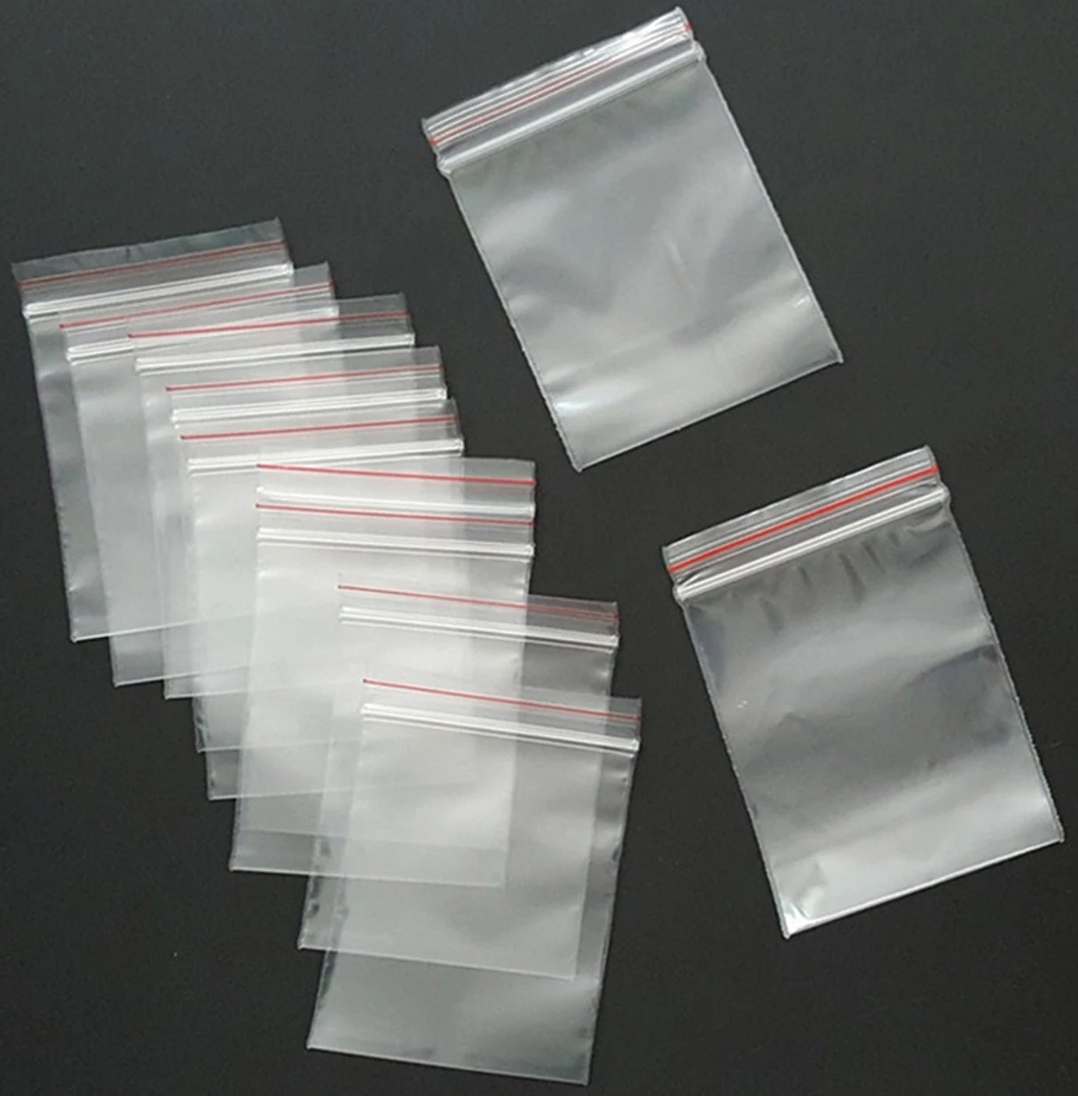 Clear plastic resealable zip bags in various sizes on black background