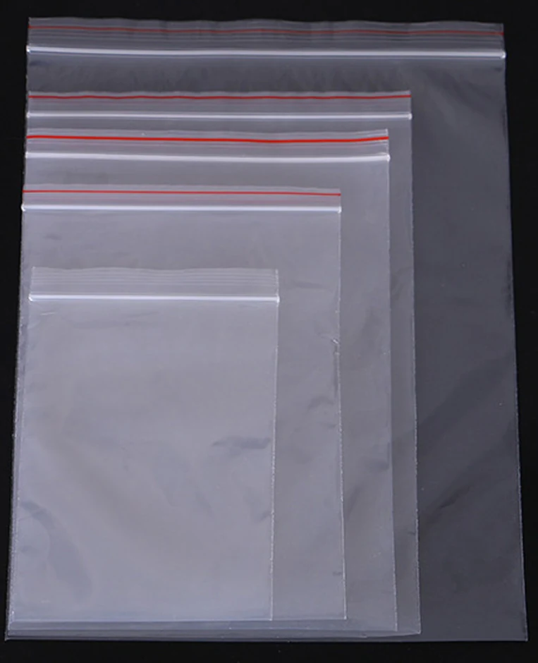 Five transparent resealable zip bags in varying sizes stacked on black background