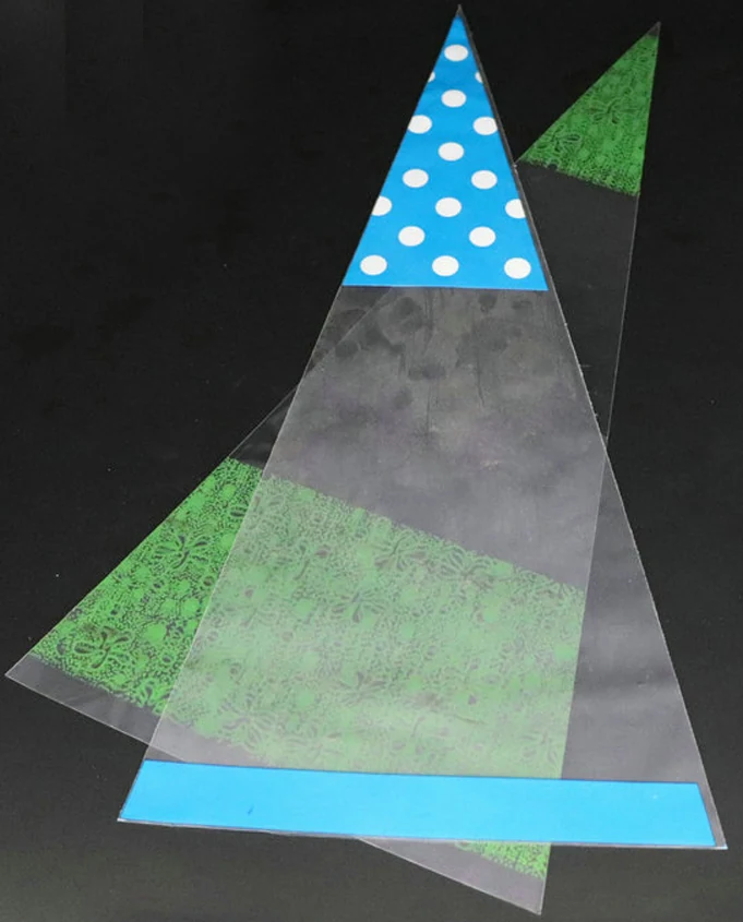 Clear cone-shaped plastic bags with blue polka-dot tops on black background