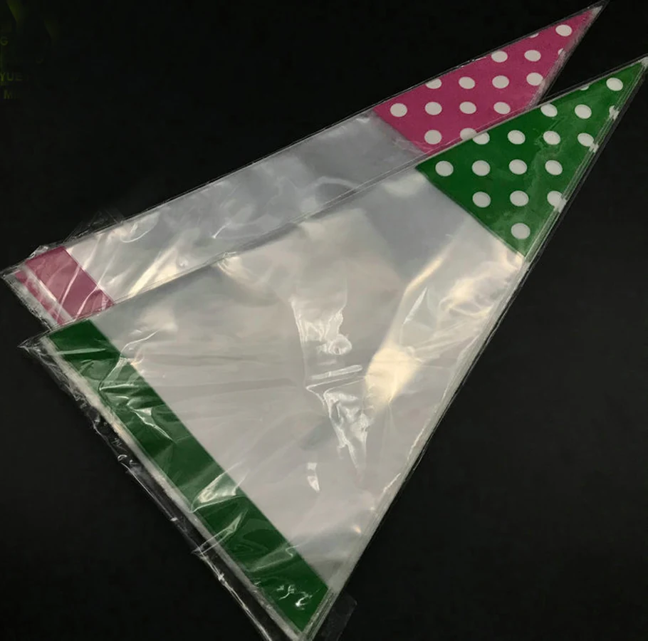 Two clear plastic cone bags with pink and green polka dot tops on black background