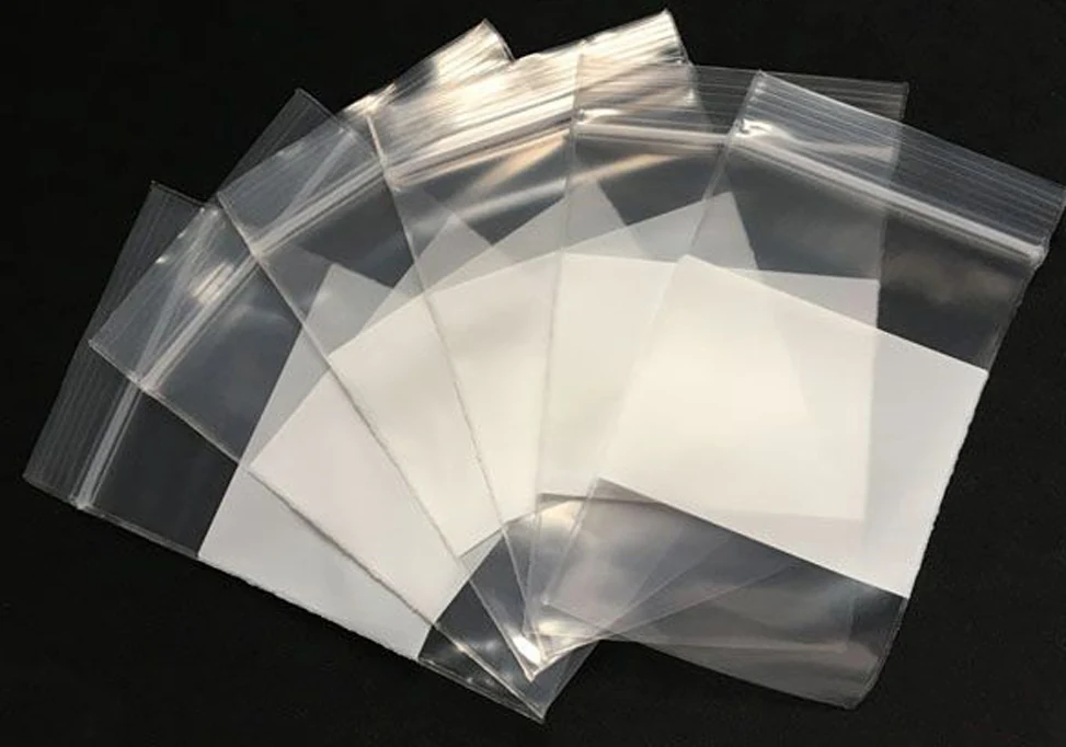 Five clear resealable zip-lock plastic bags fanned out on black background