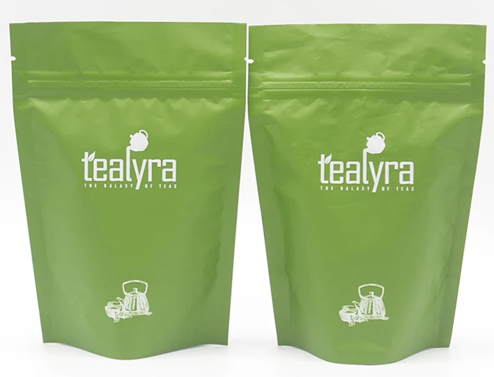 Two green resealable stand-up pouches with white logo and kettle graphics on white background