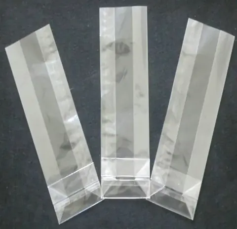Three transparent plastic side-gusset bags on dark background