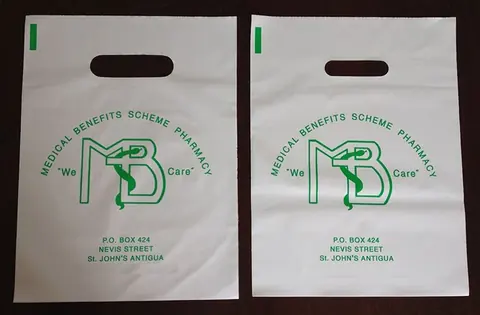 Two white plastic pharmacy bags with green printed logo and text