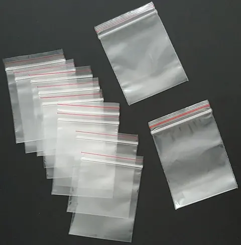 Clear plastic resealable zip bags in various sizes on black background