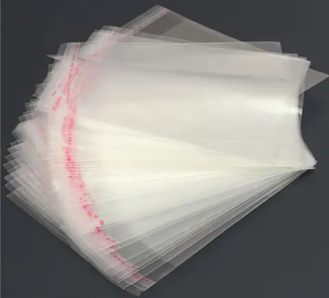 Stack of clear self-seal plastic bags fanned out on dark surface