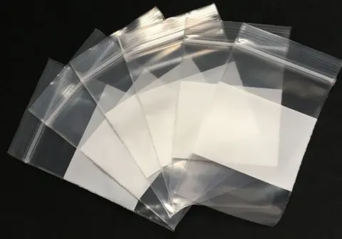 Five clear resealable zip-lock plastic bags fanned out on black background