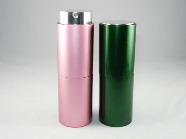 Two cylindrical cosmetic bottles, one pink with silver pump and one green with metallic cap, on white background