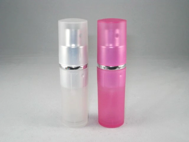 Two small cylindrical spray bottles, one frosted white and one pink, with silver collar bands and translucent caps