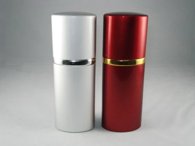 Two cylindrical cosmetic bottles, one silver and one glossy red, each with a metallic collar band