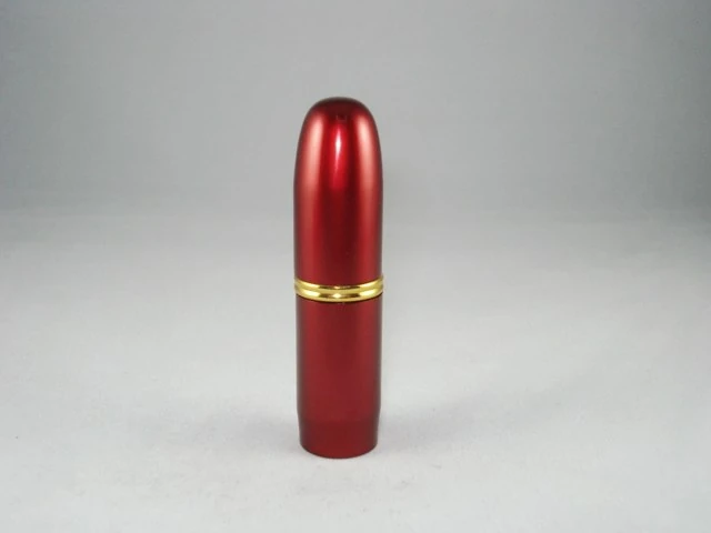 Red metallic bullet-shaped perfume atomizer with a gold band on a plain grey background