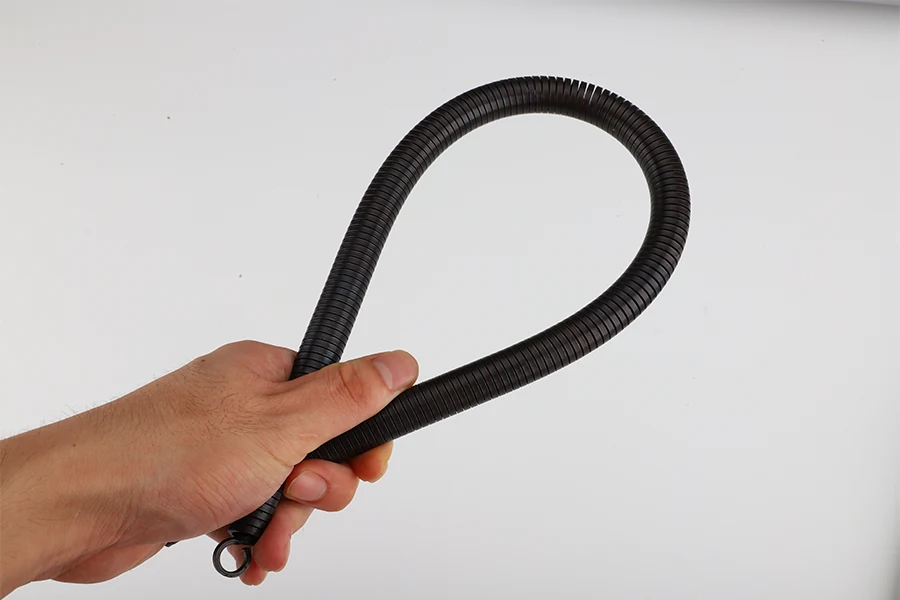 Various bending springs in different materials and finishes laid out on a surface